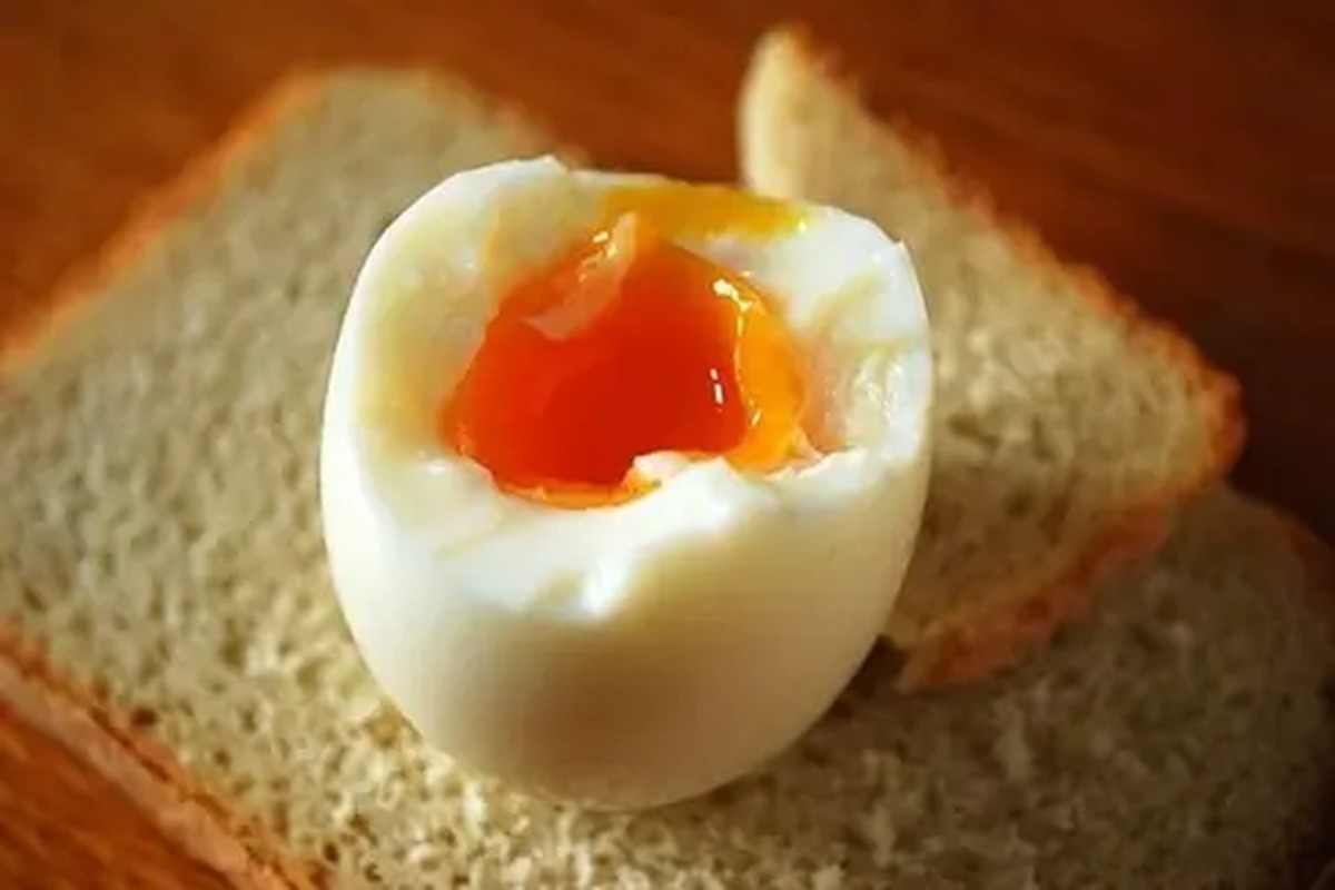 Uovo alla coque con tuorlo morbido su una fetta di pane